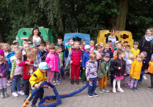 Dzieci przy kolorowych kontenerach na śmieci