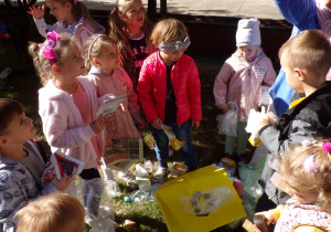 Dzieci wkładające plastikowe rzeczy do pojemnika