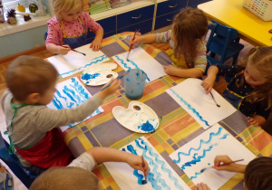 Dzieci malujące wodę farbą